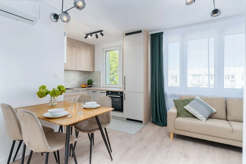 A couple collaboratively lifting a couch while moving into a new apartment.